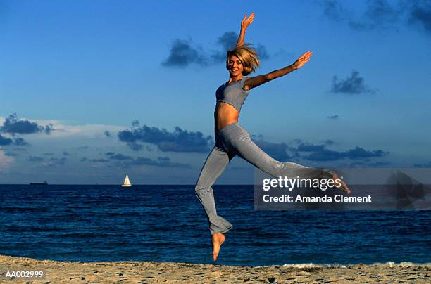 woman jumping at the beach - amanda joy stock pictures, royalty-free photos & images