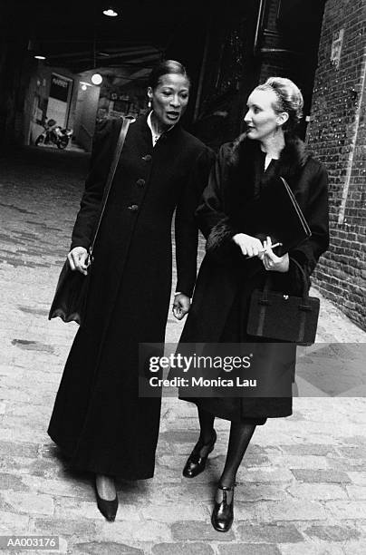 women in overcoats walking in an alley - monica askew stock pictures, royalty-free photos & images