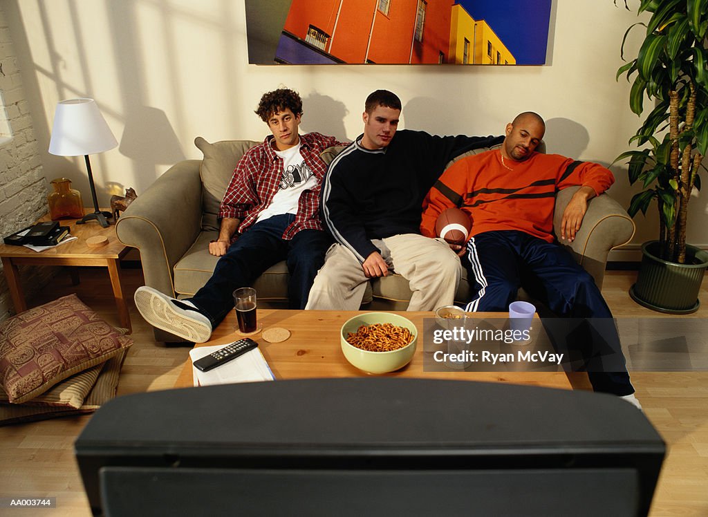 Three Men on a Couch Watching Television