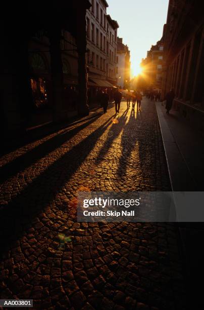 people walking down a cobblestone street - look down stock-fotos und bilder