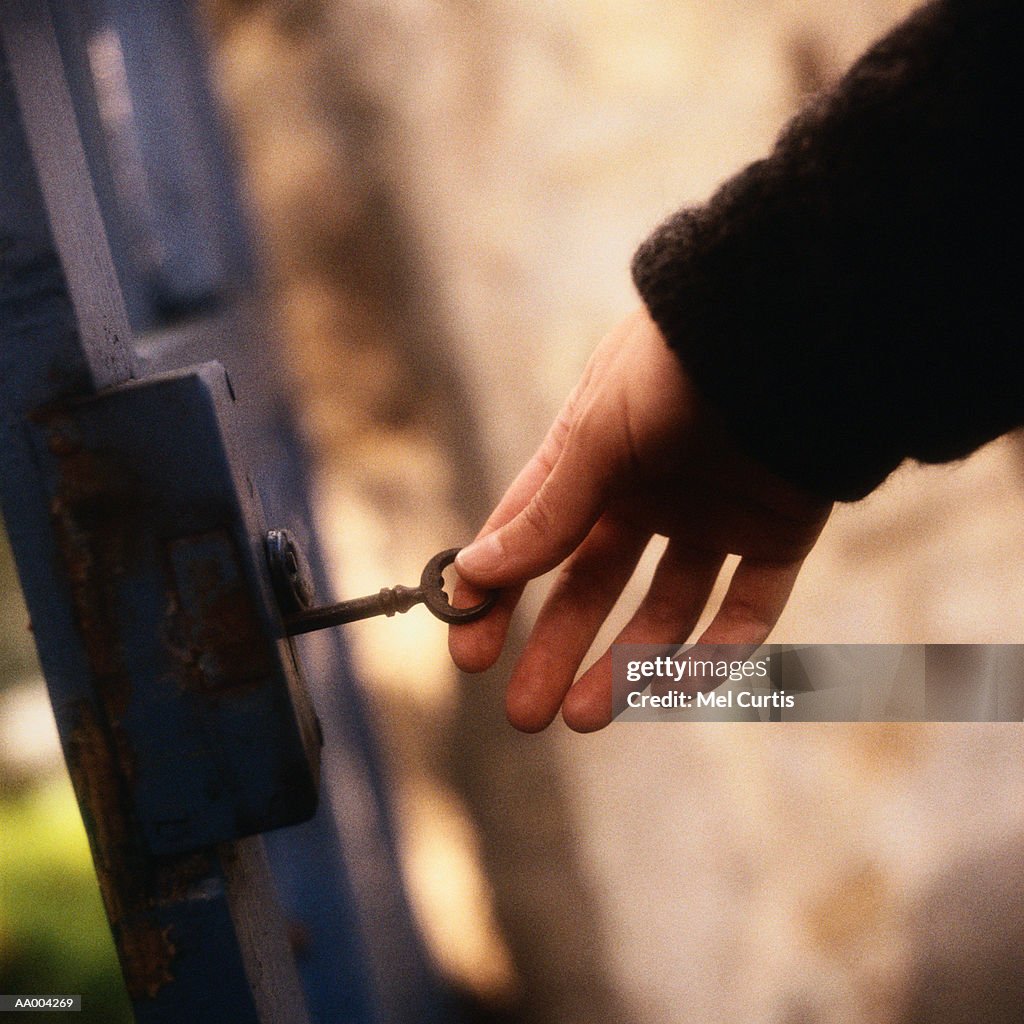 Person Unlocking a Gate