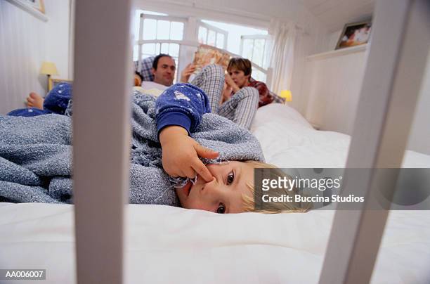 boy lying in his parent's bed - mettersi le dita nel naso foto e immagini stock