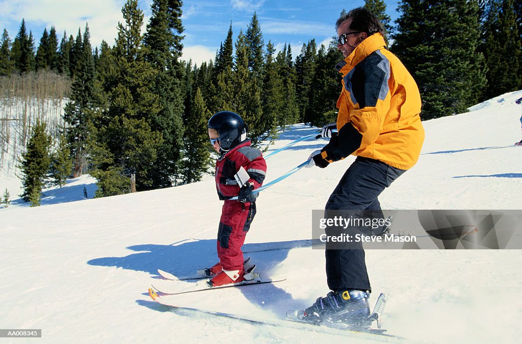 Man Helping His Daughter Learn to Ski