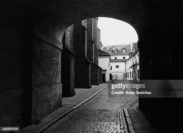 cobblestone street under an arch in warsaw, poland - mazowieckie province stock pictures, royalty-free photos & images