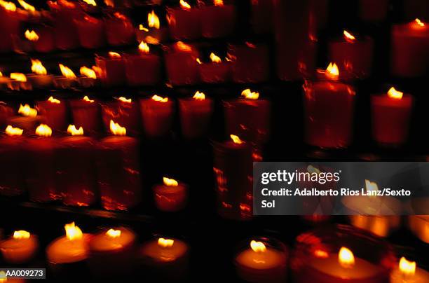 rows of candles burnig, long exposure - teelicht stock-fotos und bilder