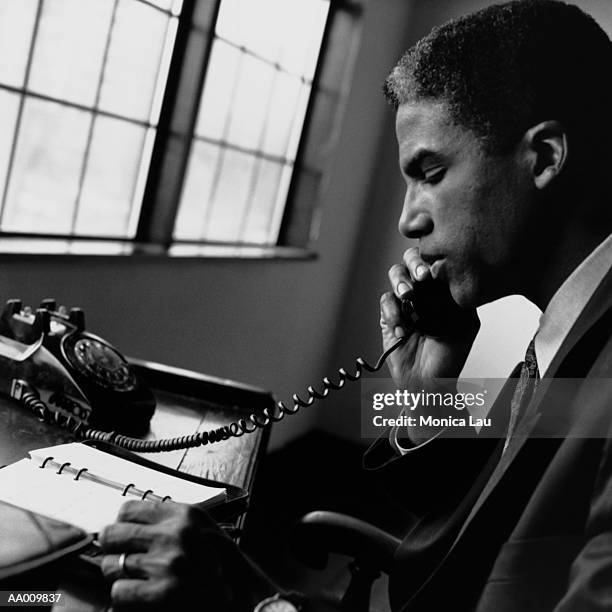 portrait of a businessman talking on a telephone - monica askew stock pictures, royalty-free photos & images