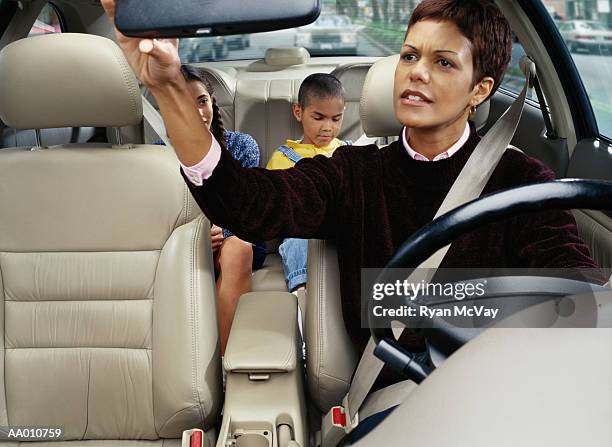mother looking at her children in the back seat - arguing blacks stock pictures, royalty-free photos & images