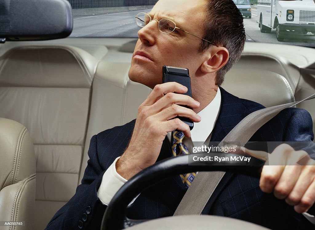 Businessman Shaving While Driving to Work