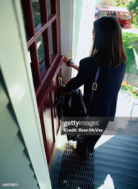 woman opening a front door - aa010811 stock pictures, royalty-free photos & images