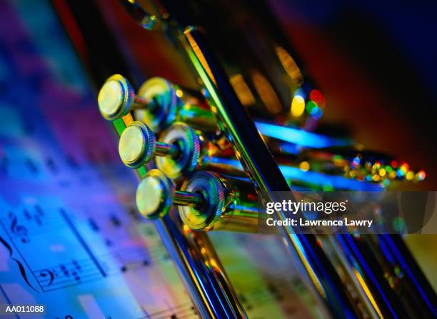 detail of a trumpet lying on a musical score - strumento musicale foto e immagini stock