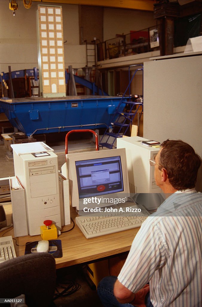 Rear View of a Seismologist Using a Computer