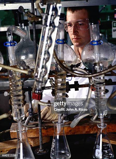 chemist performing a scientific experiment - condenser stock pictures, royalty-free photos & images