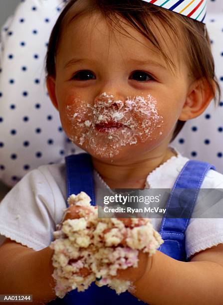 portrait of a baby with birthday cake on her face - supersensorial fotografías e imágenes de stock