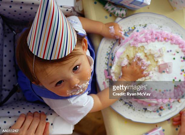 baby with her hands in her first birthday cake - eerste verjaardag stockfoto's en -beelden
