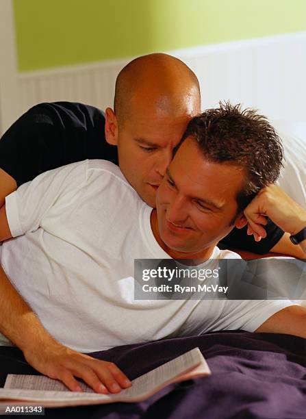 affectionate couple on a bed - couple whispering in bed stock pictures, royalty-free photos & images