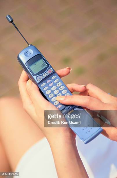 above view of a woman dialing a cellular phone - feature phone stockfoto's en -beelden