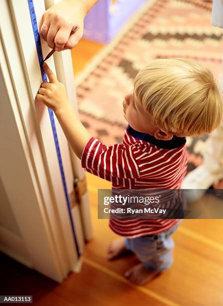 boy reading his height measurement - height chart stock pictures, royalty-free photos & images