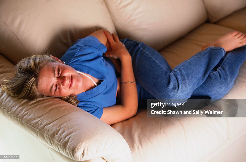 Girl in Pain Lying on the Couch