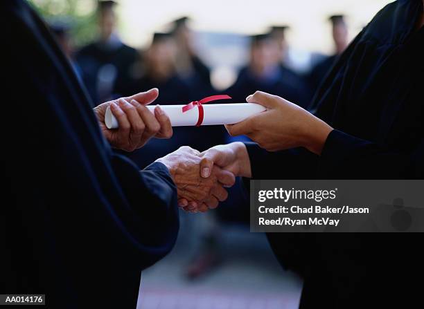 graduate receiving a diploma, close-up of hands - degree stock-fotos und bilder