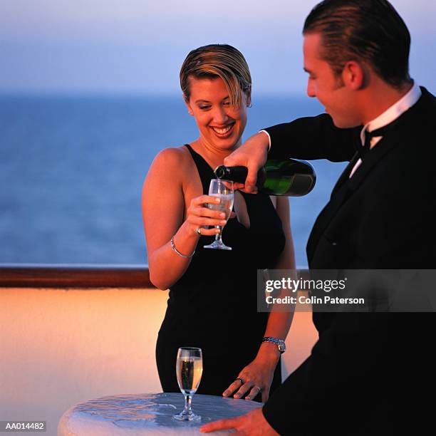 couple drinking champagne on a cruise ship - abendgarderobe stock-fotos und bilder