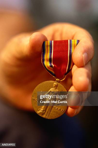 hand holding a medal from world war ii - ii stock pictures, royalty-free photos & images