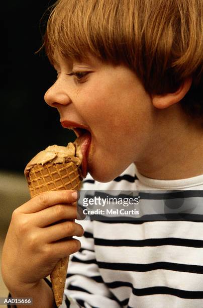 boy eating an ice cream cone - supersensorial fotografías e imágenes de stock