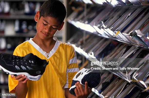 buying shoes - teenager boy shopping stock-fotos und bilder