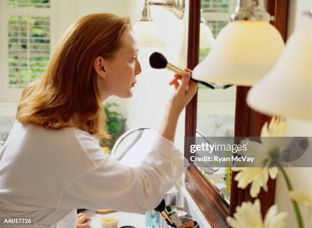 woman applying makeup in the bathroom - blusher brush stock pictures, royalty-free photos & images