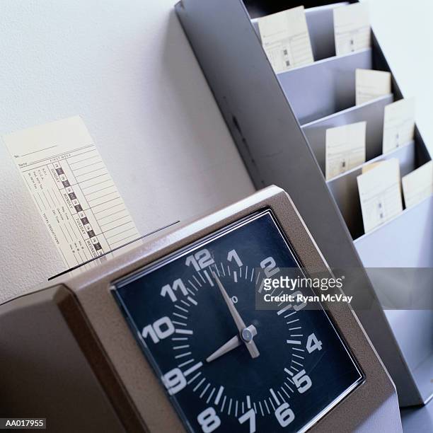 time clock marking a time card - primo turno foto e immagini stock
