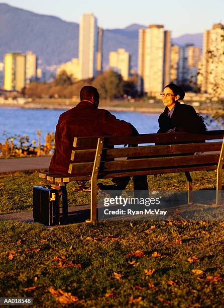 two people sitting on a park bench - bank of canada stephen poloz speaks at durham college stockfoto's en -beelden