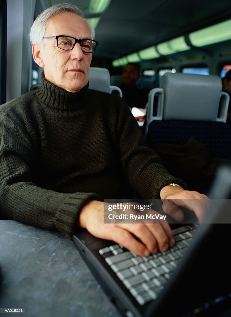 Businessman Working at a Laptop on a Train