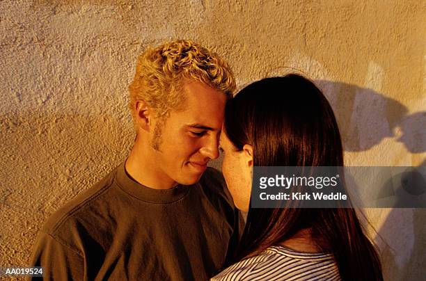 teen couple looking into each other's eyes - headshot of a teen boy stockfoto's en -beelden