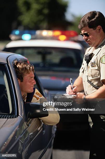 teen boy getting a speeding ticket - infrações de estacionamento - fotografias e filmes do acervo