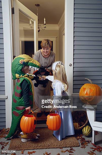 boy and girl (4-6) trick or treating on halloween - halloween candy stock-fotos und bilder
