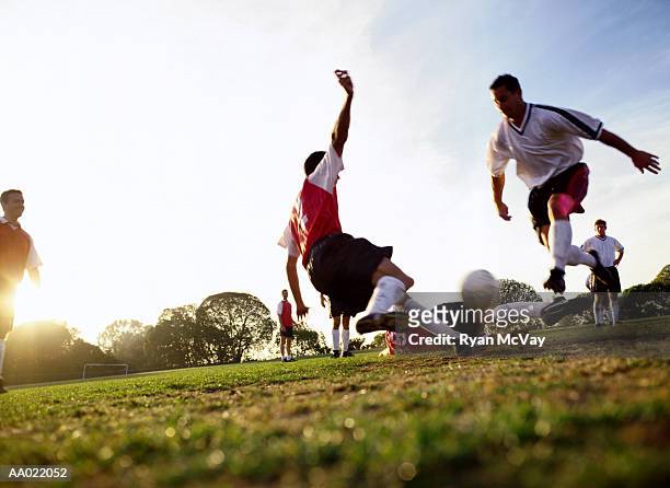 soccer players tackling for ball, ground view - tackling photos et images de collection