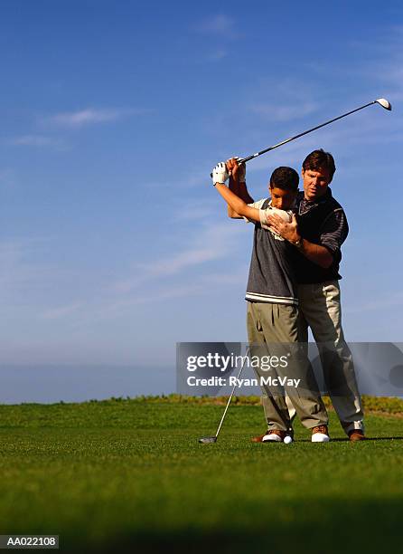 father teaching son to play golf - golf lessons stock pictures, royalty-free photos & images