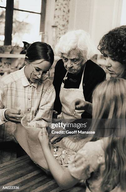 great grandmother and mother teach girls to bake - great grandmother bildbanksfoton och bilder