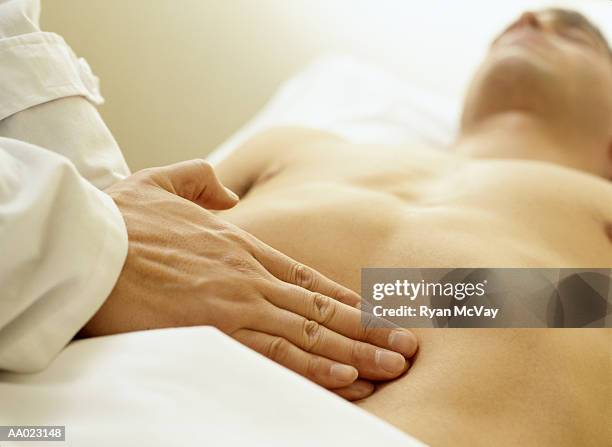 massage therapist palpating the abdomen - abdomen exam stock pictures, royalty-free photos & images