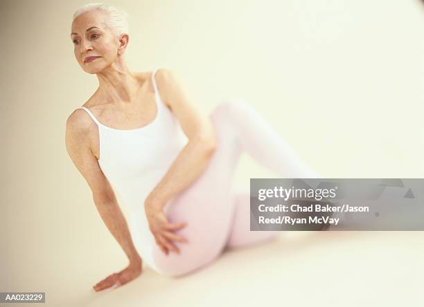 elderly woman in a yoga pose - spinal twist stock pictures, royalty-free photos & images