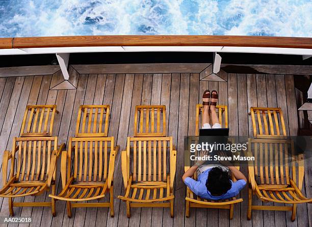 woman typing on a laptop on a cruise ship deck - cruise deck stock pictures, royalty-free photos & images