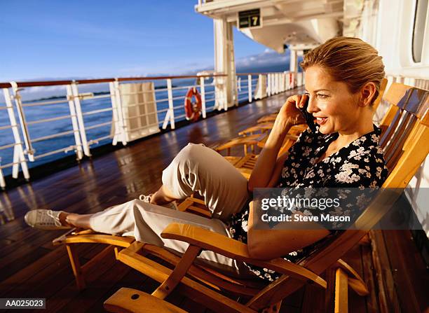 woman talking on a phone on a cruise ship deck - cruise ship stock-fotos und bilder