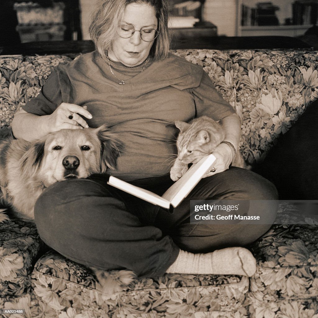 Woman Reading with Dog and Cat on Couch