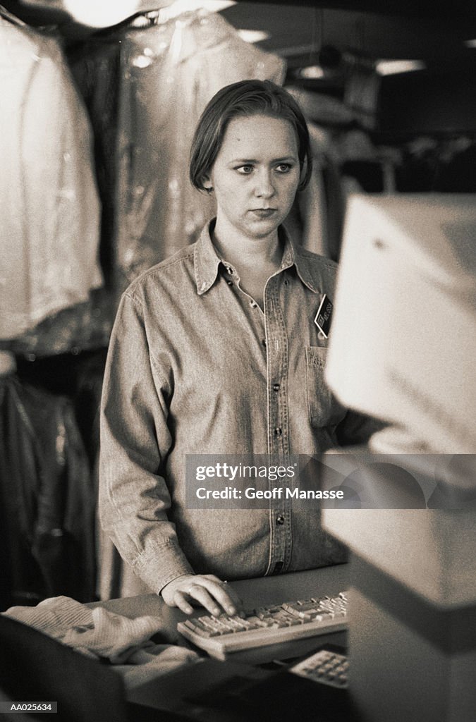 Woman Using a Computer in a Dry Cleaning Shop