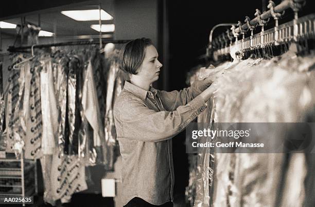 woman working in a dry cleaning shop - dry cleaning bag stock pictures, royalty-free photos & images