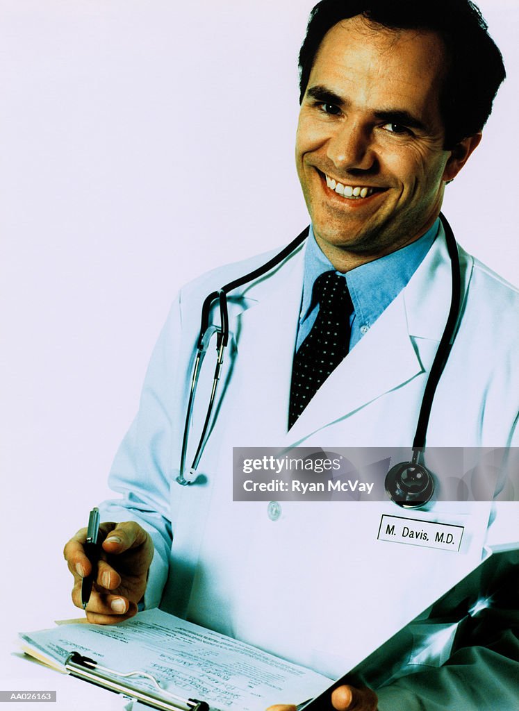 Doctor smiling, holding chart, portrait