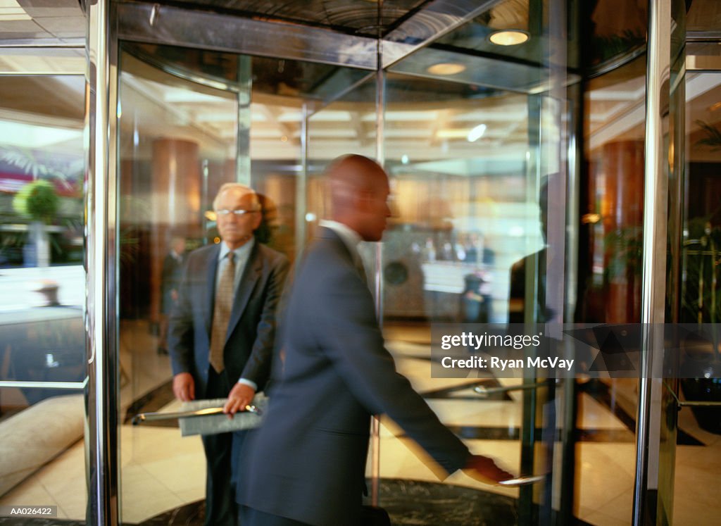 Businesspeople Walking Through a Revolving Door