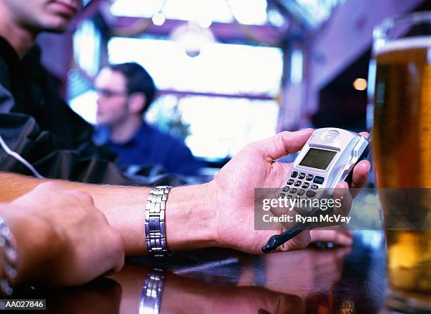 man using cellular phone in a bar - processo cruzado imagens e fotografias de stock