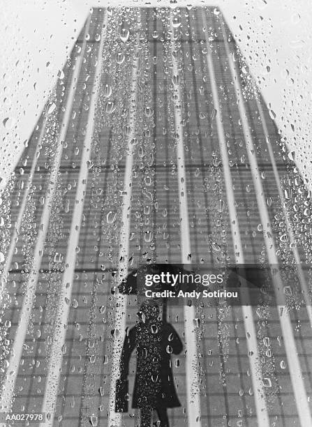 silhouette of business person standing in the rain - fensterfront innen stock-fotos und bilder