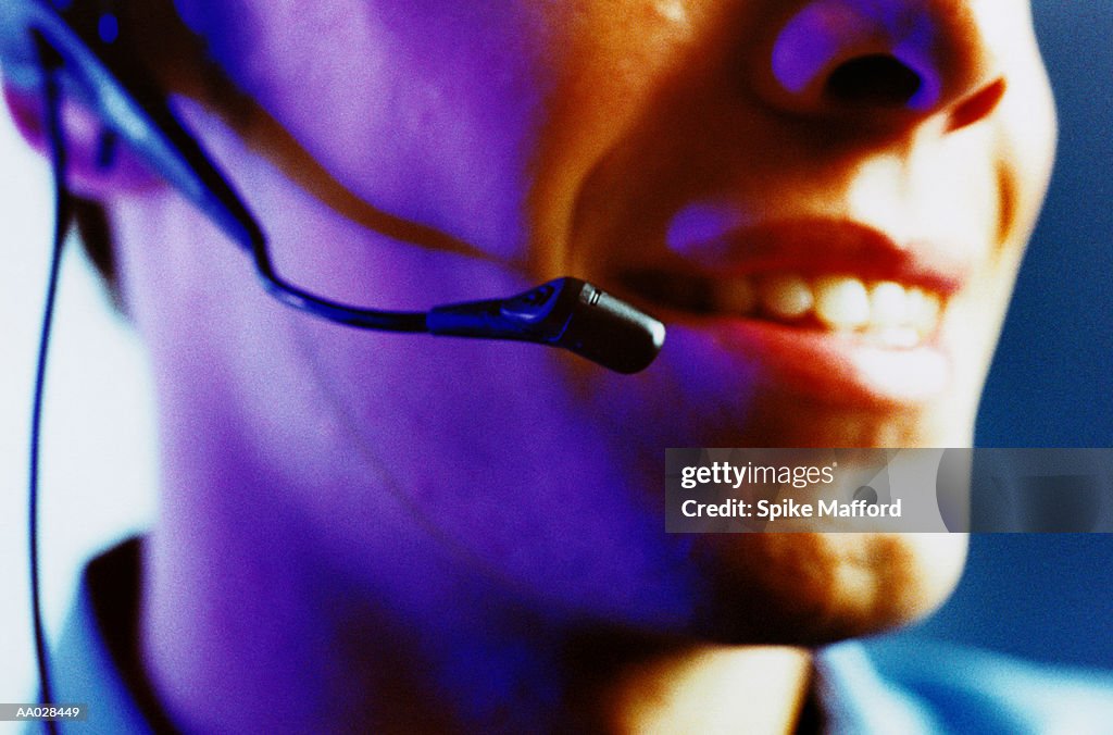 Detail of a Smiling Man's Mouth and Headset