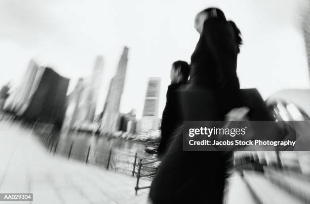 business people walking near city skyscrapers - candid black and white corporate stock pictures, royalty-free photos & images